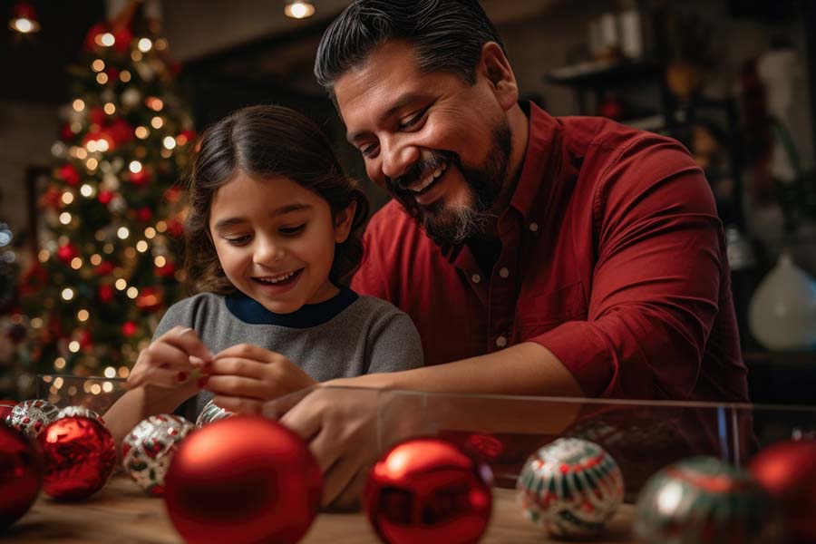 A Latino father and daughter put together Christmas ornaments.