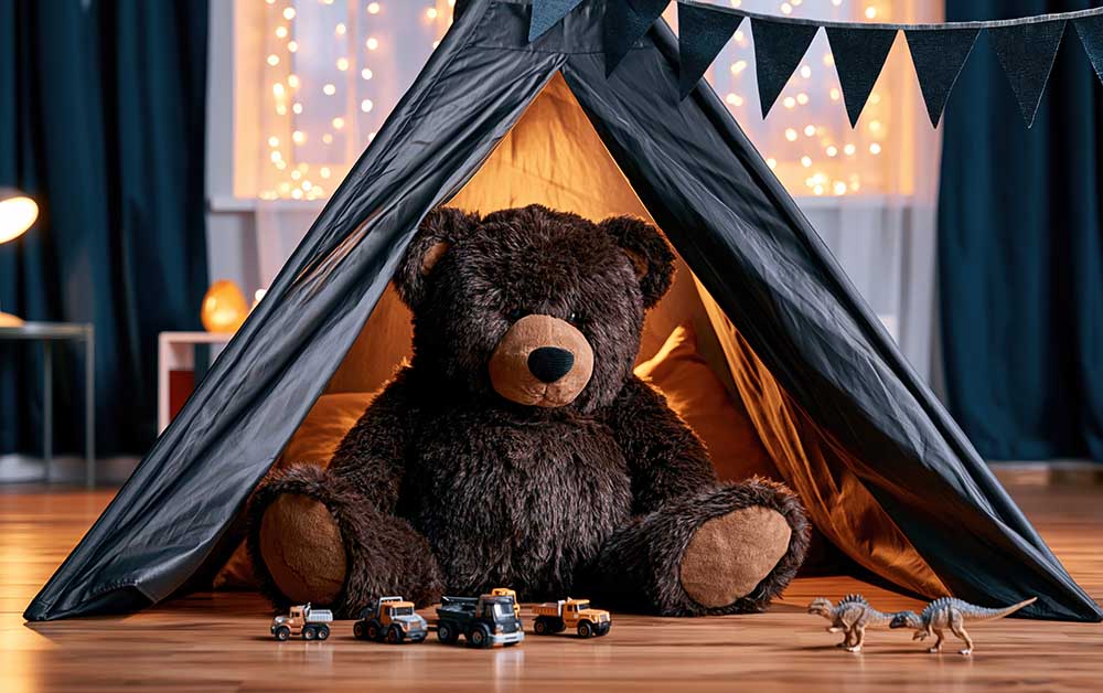 A teddy bear sits in an indoor tent.